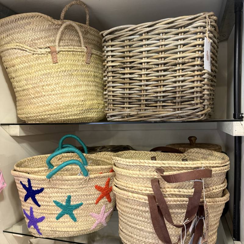 Straw and rattan shopping baskets on glass shelves